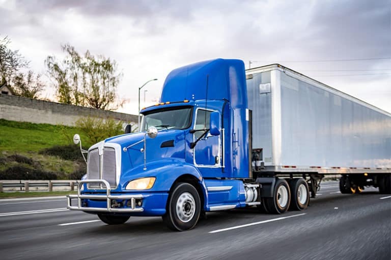 blue-tractor-trailer-truck-driving-on-road