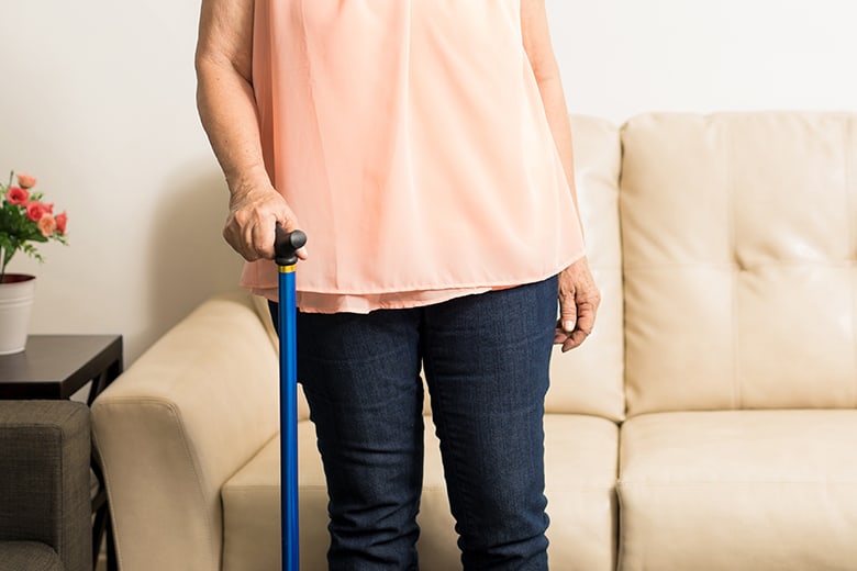 woman-with-cane-in-front-of-couch